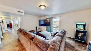 a living room with a large couch and a video game at Red Cliff Condos #1H in Moab