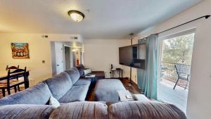 a living room with a large couch and a large window at Red Cliff Condos #1H in Moab