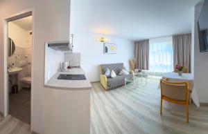 a living room with a couch and a table in a room at Hotel Ascona Bad Krozingen Frisch renoviert in bester Lage, nahe Autobahn, Kurpark und Vita Classica in Bad Krozingen +66 photos