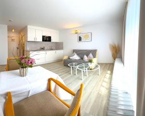 a living room with a table and a couch at Hotel Ascona Bad Krozingen Frisch renoviert in bester Lage, nahe Autobahn, Kurpark und Vita Classica in Bad Krozingen