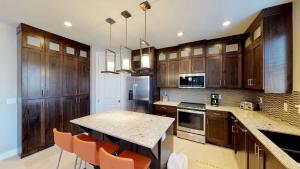 a kitchen with wooden cabinets and a table with orange chairs at Entrada at Moab #628 in Moab