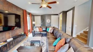 a living room with a leather couch and a ceiling fan at Entrada at Moab #430 in Moab