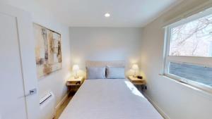 a white bedroom with a bed and two lamps at Slot Canyon #B in Moab