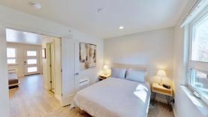 a white bedroom with a bed and two lamps at Slot Canyon #B in Moab +4 photos
