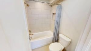 a bathroom with a toilet and a tub and a sink at Slot Canyon #C in Moab +6 photos
