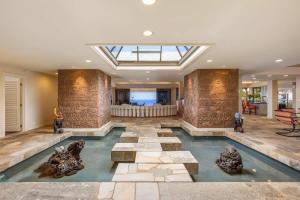 a swimming pool with rocks in the middle of a room at Waterfall House - Hawaii in Kailua-Kona