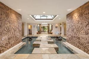 a lobby with stone walls and a pool at Waterfall House - Hawaii in Kailua-Kona