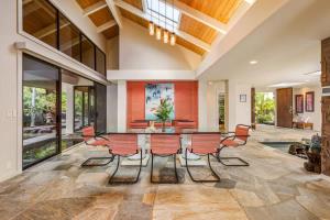 a dining room with a glass table and chairs at Waterfall House - Hawaii in Kailua-Kona
