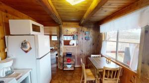 a kitchen with a refrigerator and a table in a room at Pack Creek ~ Trails End in Spanish Valley