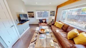 a living room with a brown leather couch at Moab Flats #4 in Moab +33 photos