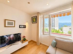 a living room with a large tv and a window at Alex Apartments in Budva
