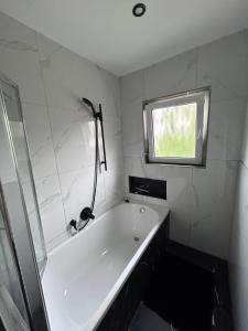 a white bath tub in a bathroom with a window at Ferienwohnung Nordheim in Nordheim +13 photos