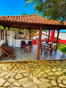 a patio with a table and chairs and a roof at Pousada Recanto da Serrinha in Corumbá de Goiás +3 photos