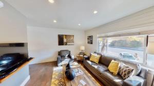 a living room with a leather couch and a television at Moab Flats #6 in Moab