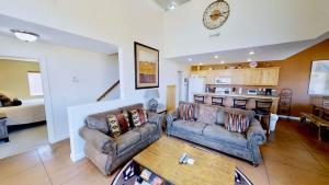 a living room with two couches and a kitchen at Saddle Creek #3A1 in Moab