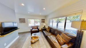 a living room with a leather couch and a flat screen tv at Moab Flats #8 in Moab