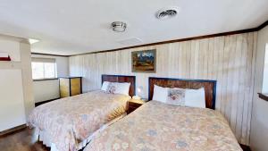 two beds in a small room with wooden walls at Pack Creek ~ Creekside West in Moab
