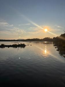 a view of a lake with the sun setting at Corrib View Villa - Guest Accomodation in Cong +15 photos