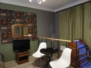 a room with a table and chairs and a television at L&B House in Malbork