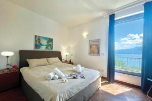a bedroom with a bed with a large window at Gaeta 'Lake View' in San Siro