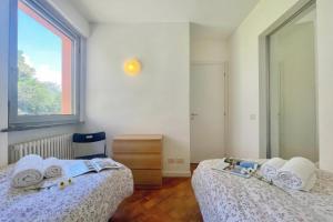 a bedroom with two beds and a window at Gaeta 'Lake View' in San Siro