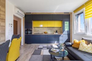 a living room with a couch and a kitchen at Sunset Resort 409 With Pool - Happy Rentals in Fonyód