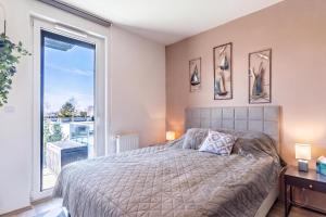 a bedroom with a bed and a large window at Sunset Resort 409 With Pool - Happy Rentals in Fonyód