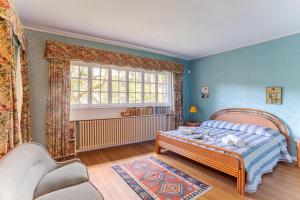 a bedroom with a bed and a chair and a window at Villa Colle in Ossuccio