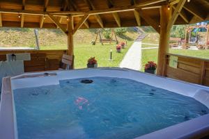 a jacuzzi tub in a house with a yard at Brzozowa Osada in Polańczyk