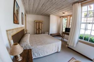 a bedroom with a bed and a large window at Ville Real Hotel in Santo Antônio do Leite