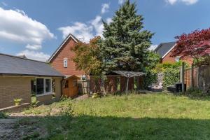 a yard with a tree and a house at Comfortable 2 Bed Apartment- Pass the Keys in Basildon