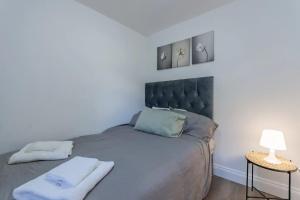 a bedroom with a bed with two towels on it at Comfortable 2 Bed Apartment- Pass the Keys in Basildon