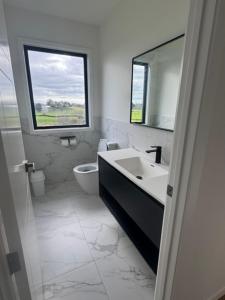 a bathroom with a sink and a toilet and a window at 1 Bedroom Granny Flat D in Runciman