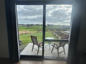 a view of a patio with a table and chairs through a window at 1 Bedroom Granny Flat D in Runciman