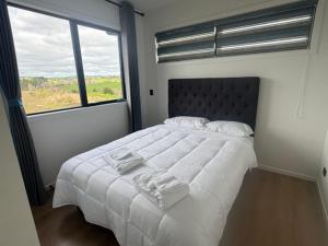 a bedroom with a large bed with two towels on it at 1 Bedroom Granny Flat D in Runciman