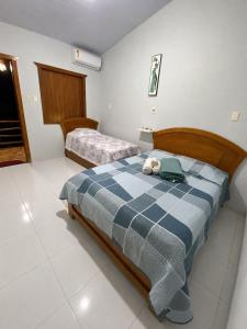 a bedroom with two beds with a blue and white blanket at Pousada Recanto da Serrinha in Corumbá de Goiás