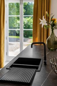 a kitchen counter with a sink and a vase with a flower at Glebe House in Sion Mills