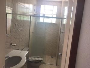 a bathroom with a shower with a toilet and a sink at Casas de Temporada Conservatória in Conservatória