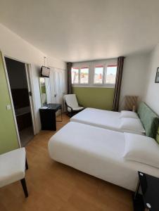 a hotel room with two beds and a couch at Hôtel de la poste in Saint-Valery-en-Caux