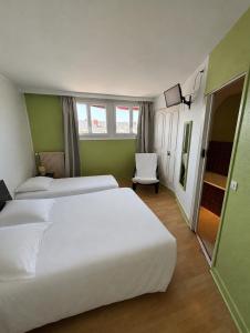 a hotel room with two beds and a chair at Hôtel de la poste in Saint-Valery-en-Caux