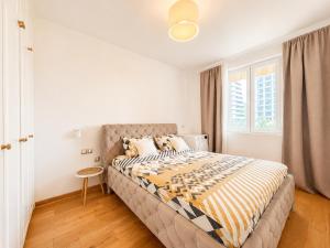 a bedroom with a bed with a yellow and white comforter at Alex Apartments in Budva