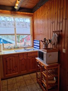 a kitchen with a microwave on a table with a window at Ferienhaus Fuchsbau in Extertal