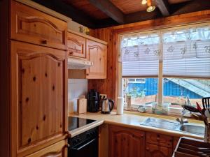 a kitchen with wooden cabinets and a sink and a window at Ferienhaus Fuchsbau in Extertal