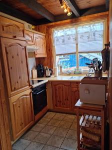 a kitchen with wooden cabinets and a window at Ferienhaus Fuchsbau in Extertal