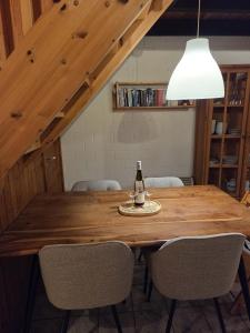 a bottle of wine on a wooden table with chairs at Ferienhaus Fuchsbau in Extertal +15 photos