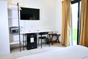 a bedroom with a desk with a tv and a bed at Ganalé Hôtel in Dakar