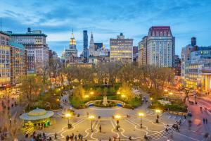 a city skyline at night with a fountain in a park at Union Nest in New York