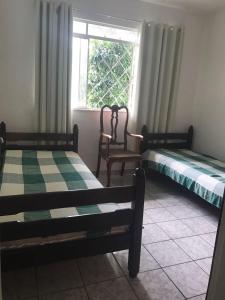 康斯沃托雅的住宿－Casas de Temporada Conservatória，两张床位于带窗户的房间内