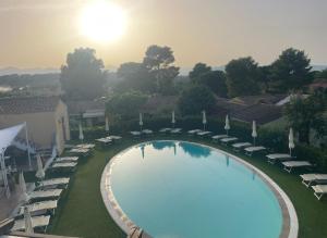 an overhead view of a swimming pool with chairs and umbrellas at Hotel Cala Mirto in Budoni