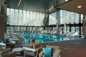 a pool in a building with chairs and a swimming pool at Crowne Plaza Belgrade by IHG in Belgrade